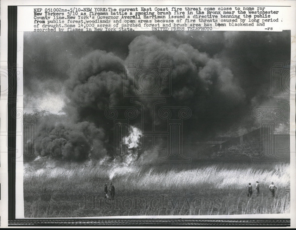 1957 Firemen battle a smoking brush fire in Bronx near Wetchester - Historic Images