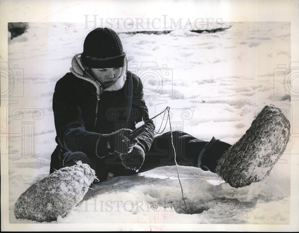 1960 Press Photo Per Olof Karlsson fishes through ice on pond in Stockholm - Historic Images