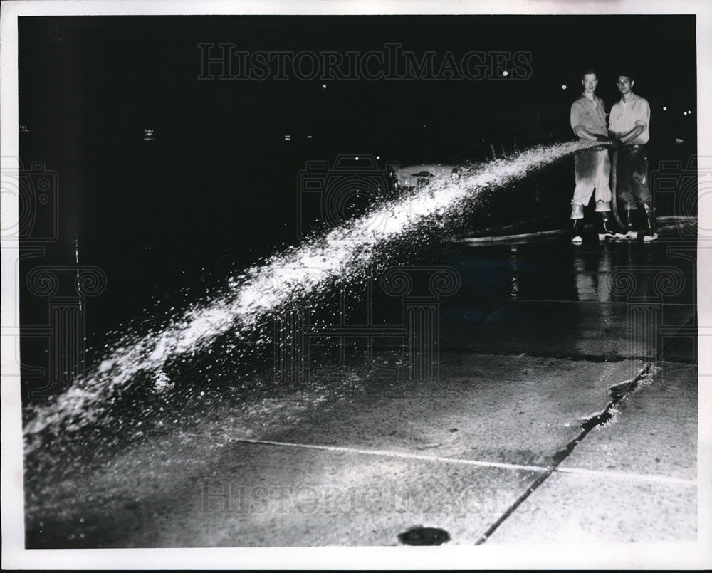 1957 Press Photo Firemen Jim Malloy, Lee Young wash sidewake in Cleveland, Ohio - Historic Images