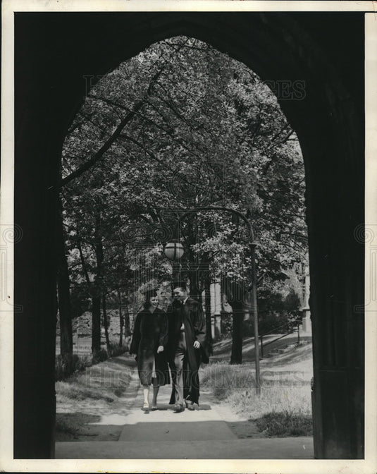Press Photo Two Grads walking under a bridge - Historic Images