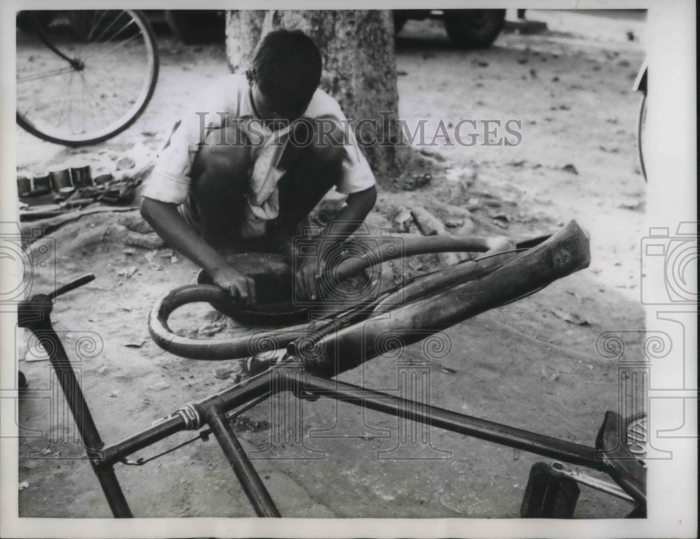 1960 Roadside repairman fixing flats in new Delhi, India - Historic Images