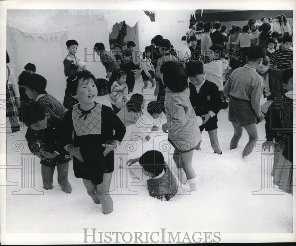 1968 Toyko, Japan children play with fake snow made from rubber - Historic Images