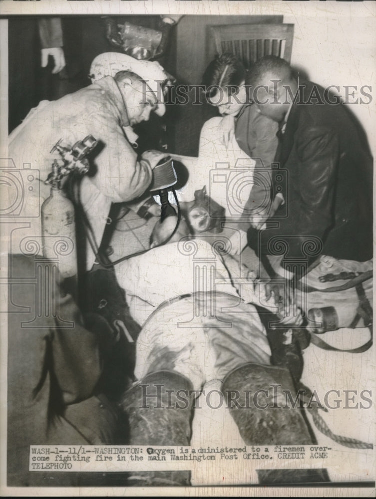 1949 Press Photo Wash.D.C.firemen administer oxygen to a fire victim - Historic Images