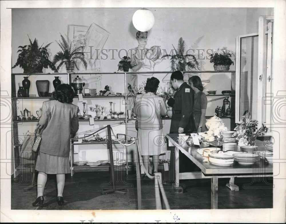1946 Press Photo A group of people examine a store&#39;s merchandise - Historic Images