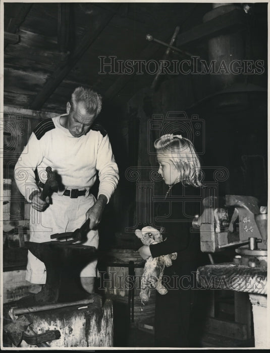 1938 Marianne Watches her father Lester pound horsehoes - Historic Images