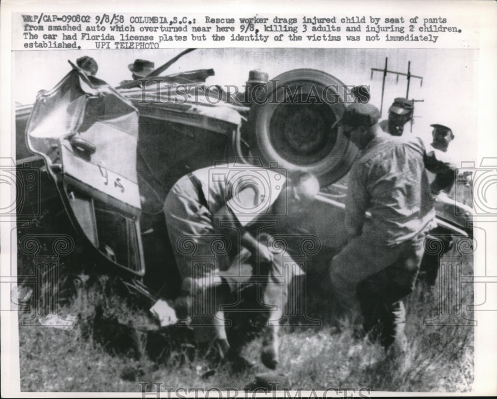 1958 Press Photo Rescue working drag injured child from overturn car in Columbia - Historic Images