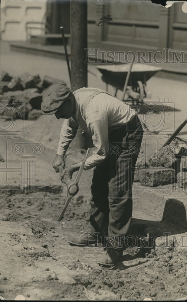 1918 Press Photo A day laborer with pick axe on construction site-Historic Images