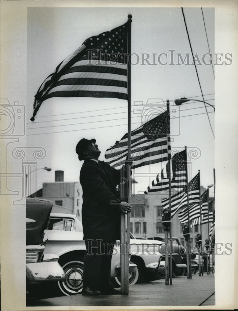 1963 Press Photo Exchange Club ember Herbert Lombard Examines Flag-Historic Images