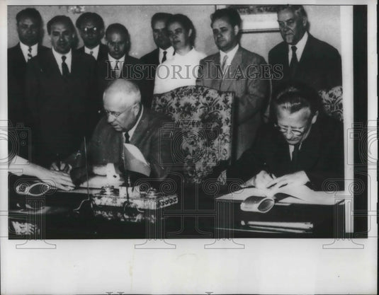 1957 Press Photo Men at a desk sign an agreement with onlookers - Historic Images
