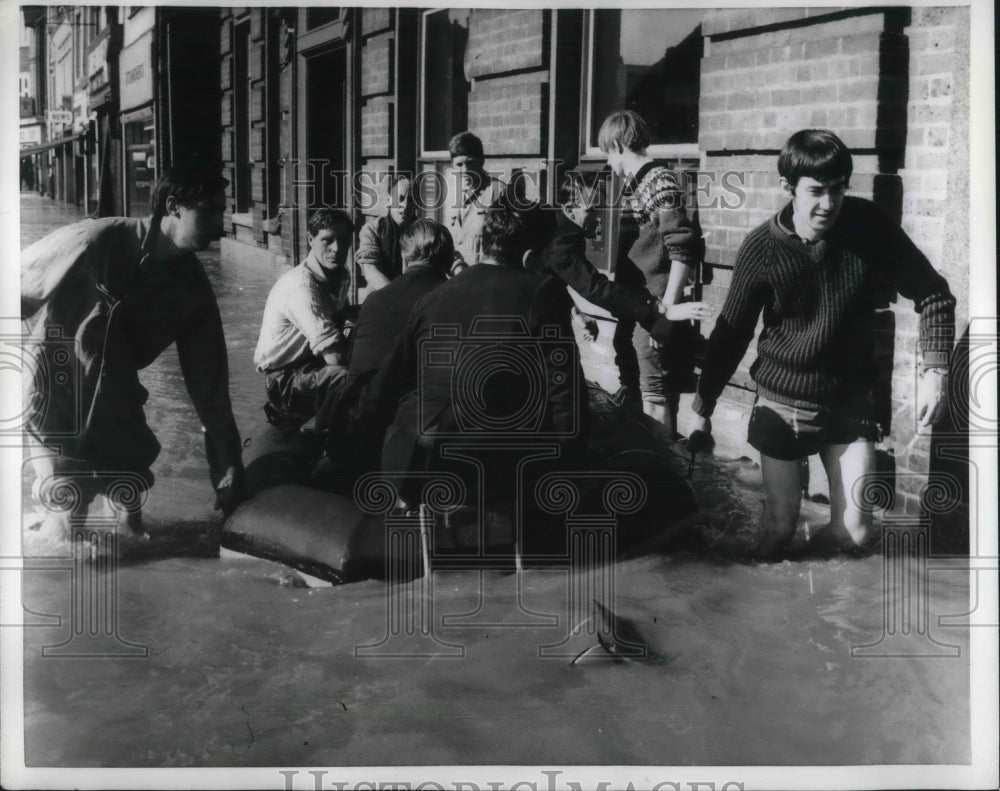 1968 Press Photo kids helping the police move a boat along a flooded street.- Historic Images
