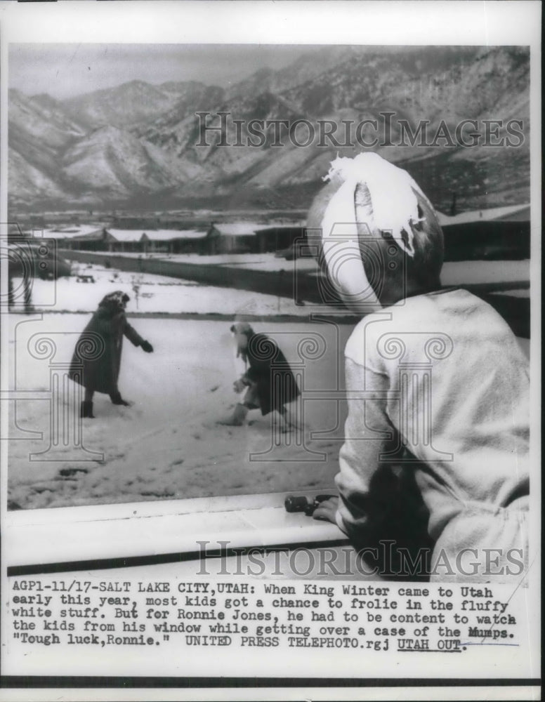 1956 Press Photo Ronnie Jones looking over the children playing in the ice - Historic Images