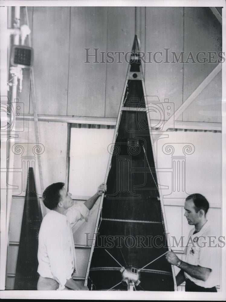 1957 Press Photo Martin Co employees inspect nose cone for test satellite - Historic Images