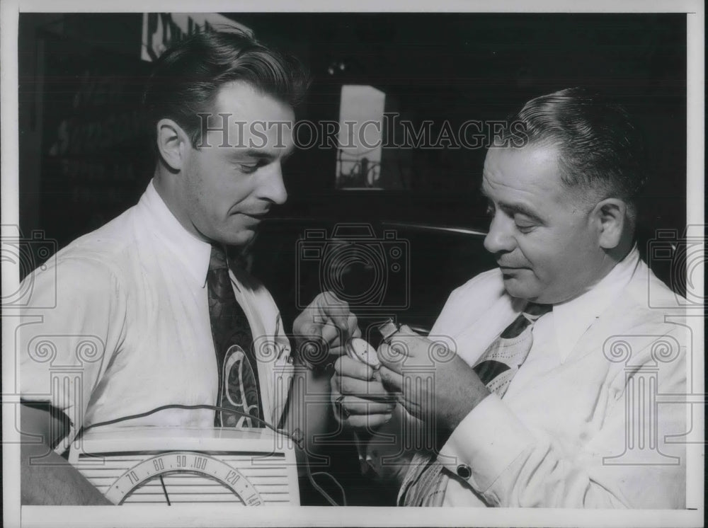 1949 Press Photo Herb Teal Examining Johnny Walker&#39;s Watch.-Historic Images