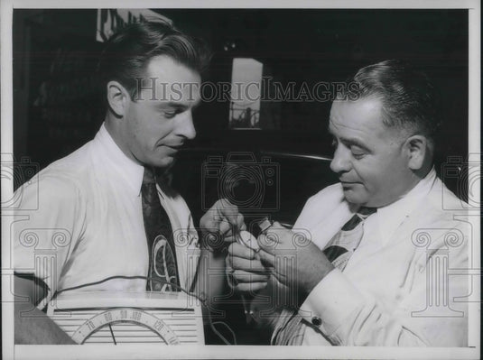 1949 Press Photo Herb Teal Examining Johnny Walker's Watch.-Historic Images