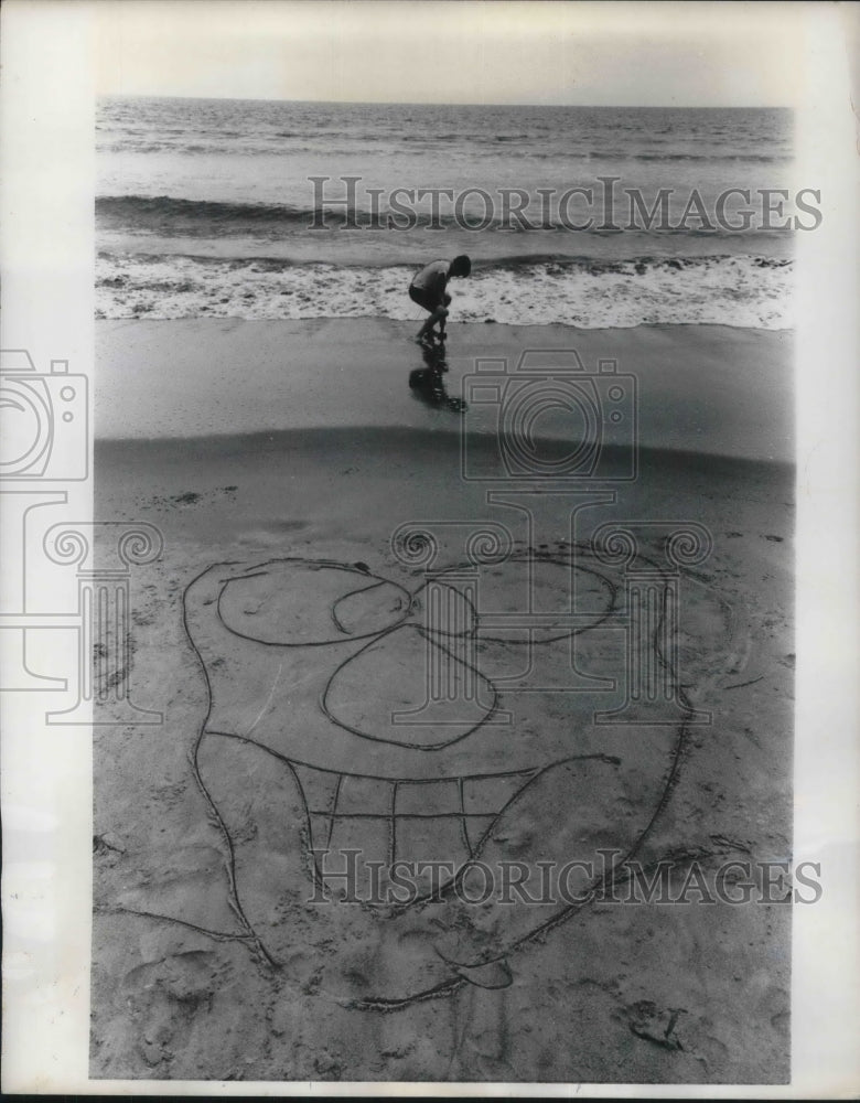 1969 Stinson Beach, Calif. cartoonist Paul Stanfield draws on beach - Historic Images
