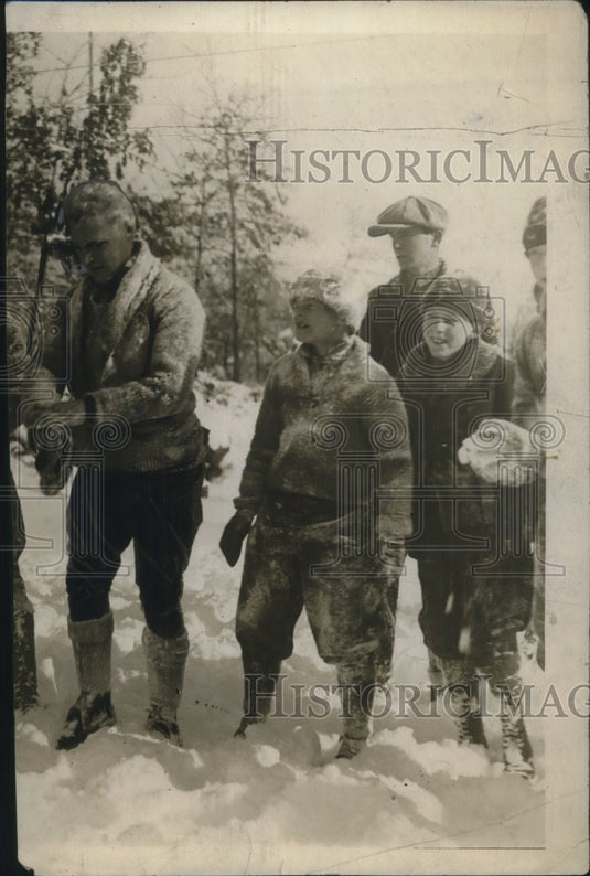 1924 Press Photo A group of children & a man playing in the snow - Historic Images