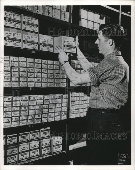 Press Photo A workman in a stock keeping room at a factory - Historic Images