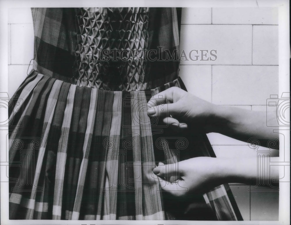 1957 A plaid pleated dress on a model  - Historic Images