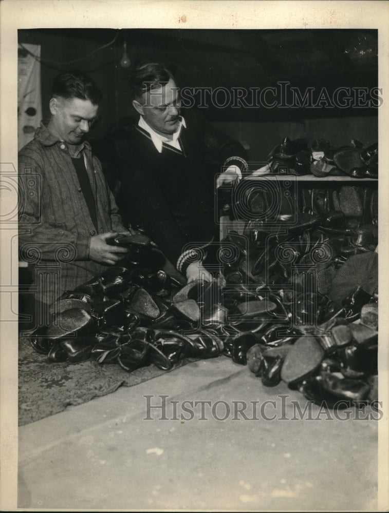 1933 Mr.Brandt &amp; Mr.Olsen of 1283 club sorting boots for Xmas needy - Historic Images