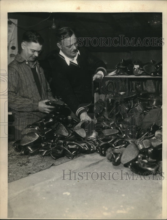 1933 Mr.Brandt & Mr.Olsen of 1283 club sorting boots for Xmas needy - Historic Images