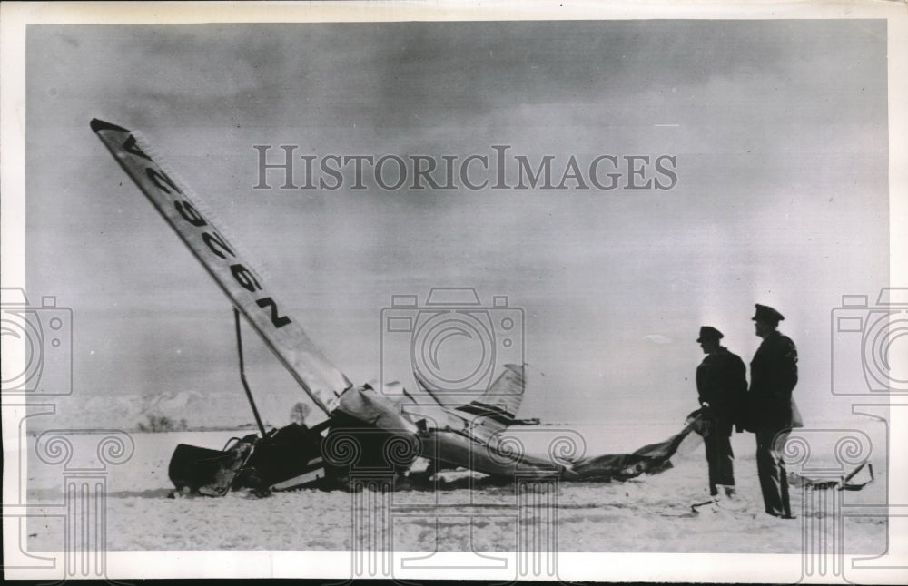 1952 Highway Patrolman inspecting wreckage of a plane in salt lake - Historic Images