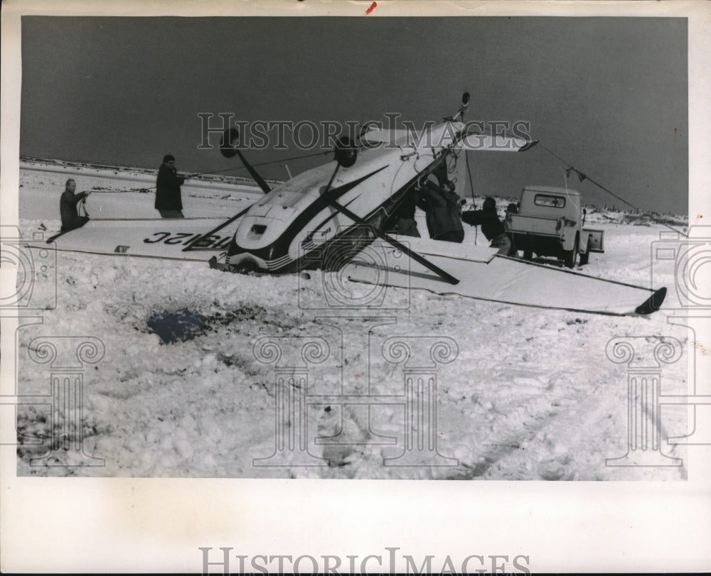 1954 Group of men turnaround the inverted plane in Lakefront Airport - Historic Images