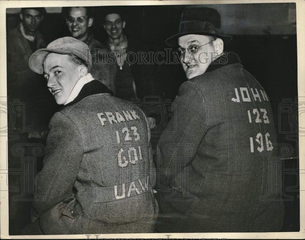 1937 Group of sitdowners making paper identification on back of coat - Historic Images