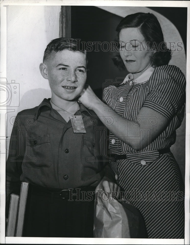 1942 Mrs Harvey Slentz fastens tag around her son Harvey - Historic Images