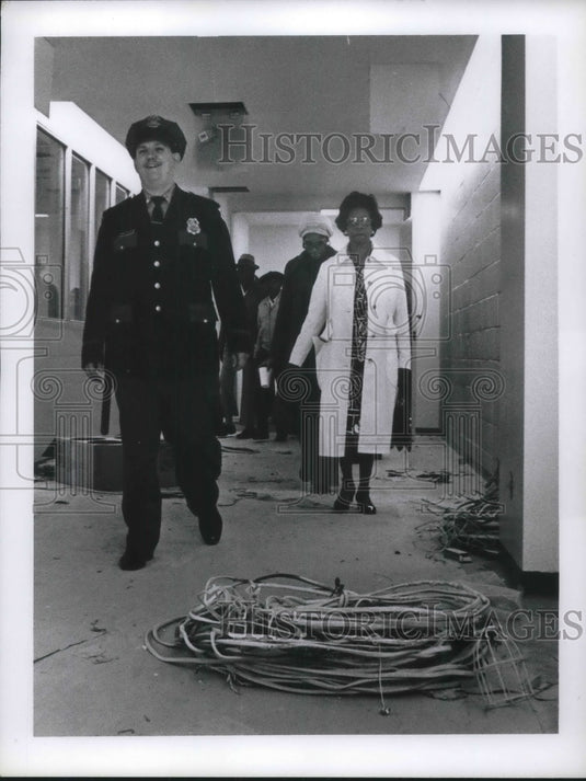 1976 Press Photo Policeman Walking Walking Down a Wrecked Hallway - Historic Images