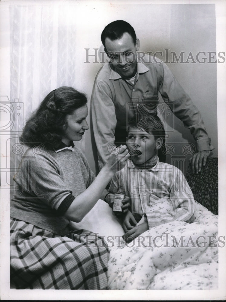 1957 Press Photo Julius Penzes Looks On While His Wife Gives Medicine To Son - Historic Images