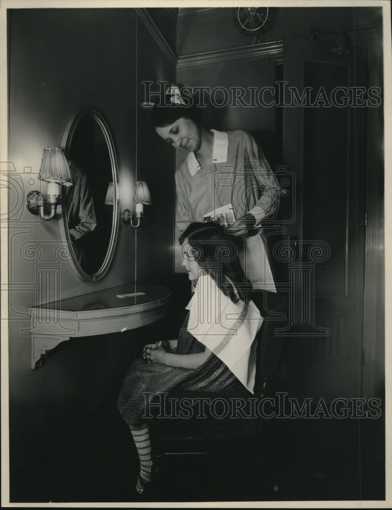 1929 Press Photo Lady does little girls hair - Historic Images