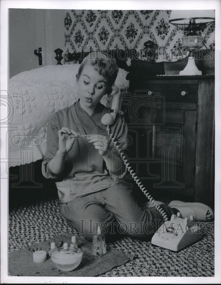 1955 Manicure while talking on phone - Historic Images