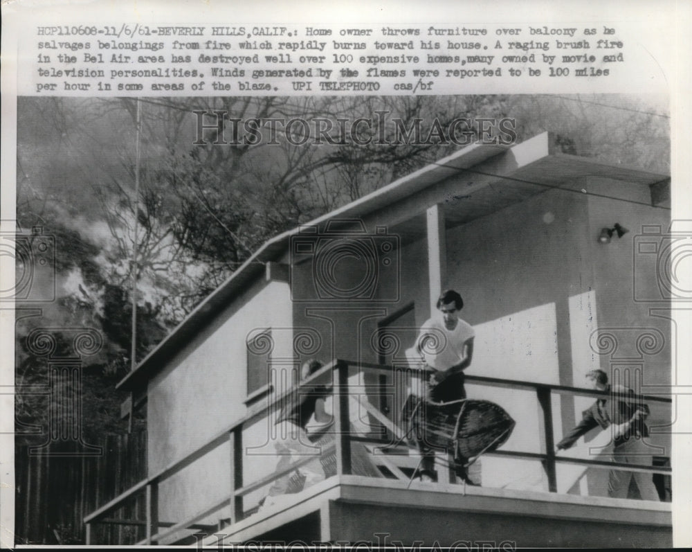 1961 Press Photo Man Throws Furniture Over Balcony To Save From Bel Air Fire - Historic Images