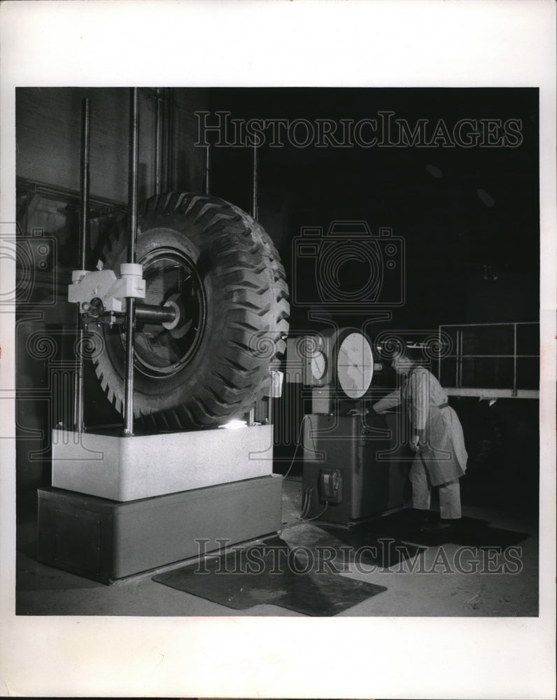 Press Photo worker performing test on a truck tire - Historic Images