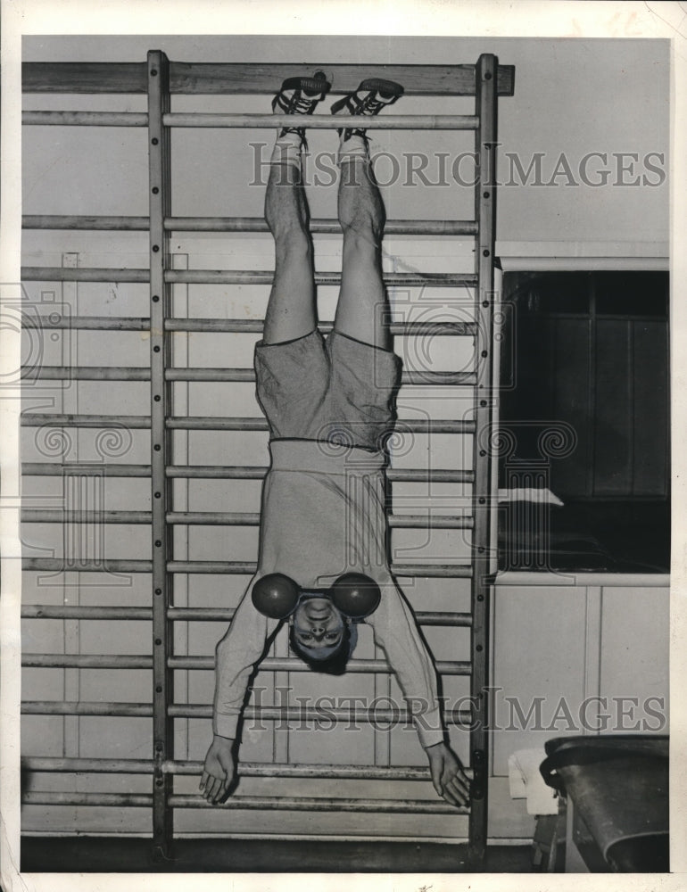 1942 Press Photo Albert Prudence, dangling by his feet w/ a 25 lbs dumbbell - Historic Images