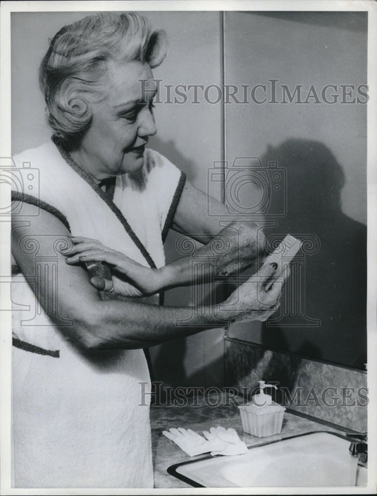 1961 Press Photo woman scrubbing dead skin from her arms, demos good hygiene - Historic Images