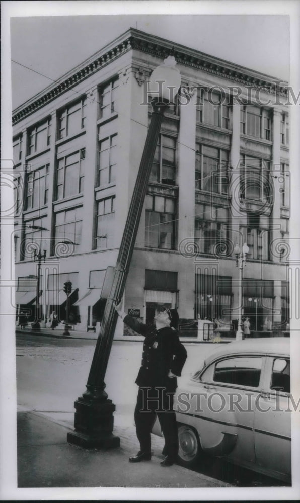 1954 Press Photo Cop DW Dunning Holds Up Base Of Street Lamp Awaiting Repair - Historic Images