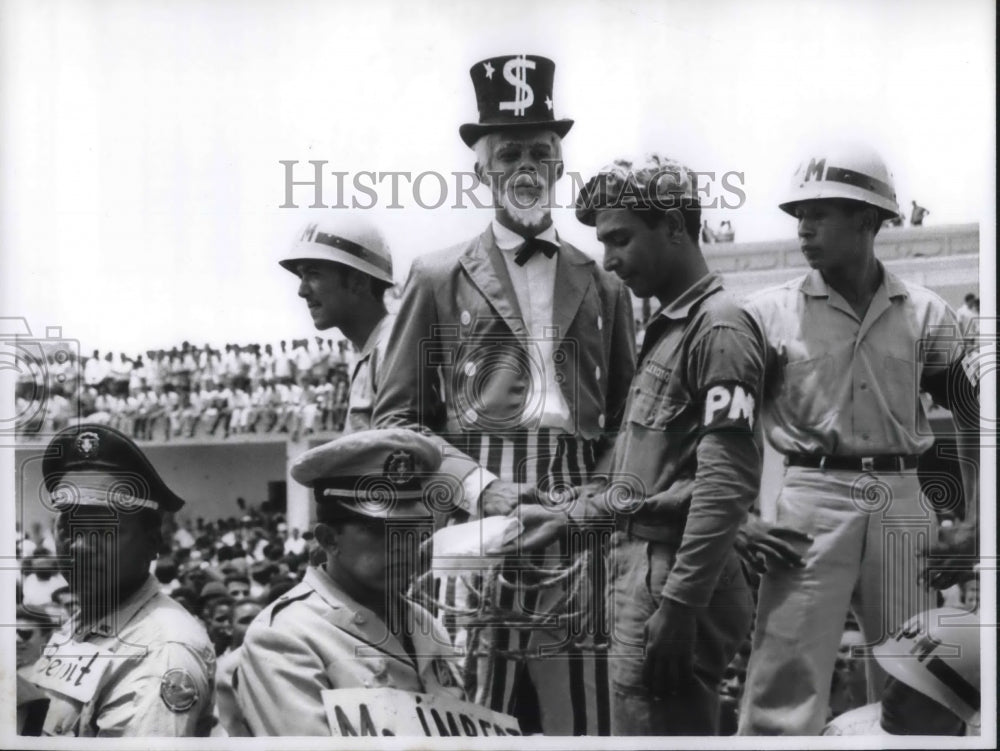 1965 Press Photo A rebel portraying Uncle Sam with a coil of rope in his hands. - Historic Images