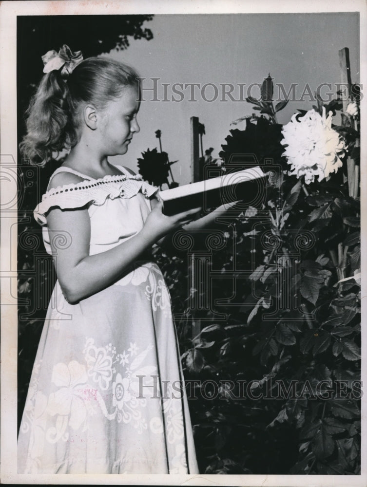 1952 Marry Ann Serschen standing next to flowers - Historic Images