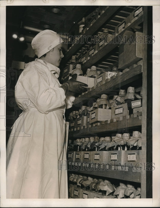 1939 An operator depositing bottles of serum at the serum bank. - Historic Images