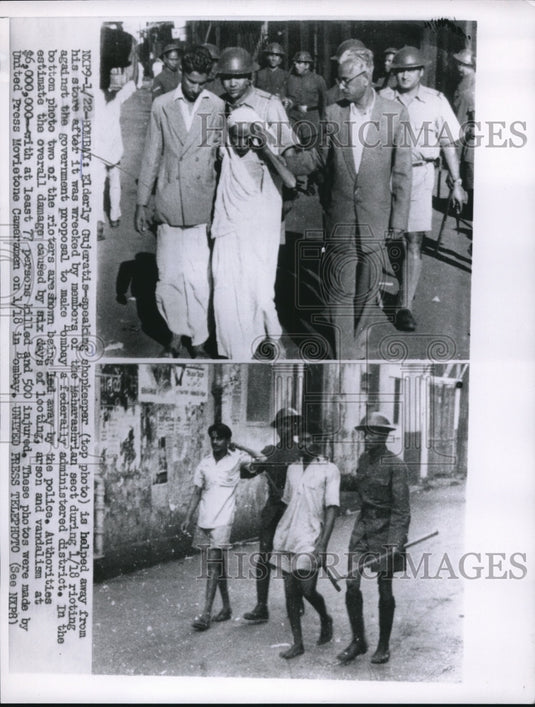 1956 Press Photo Gujeratis-speaking shopkeeper helped from wrecked store - Historic Images