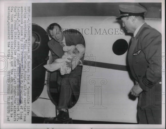 1955 Press Photo Baby John Stapleton carried by his father from Ambulance Plane. - Historic Images