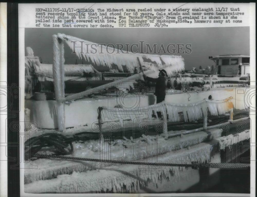 1959 Press Photo Lou Belanger hammers away ice on the tanker &quot;Taurus&quot;-Historic Images