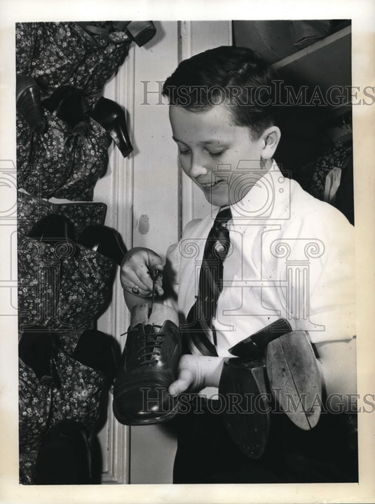 1943 Junior Takes Pair Of Shoes Off Shoe Tree For Daily Cleaning - Historic Images