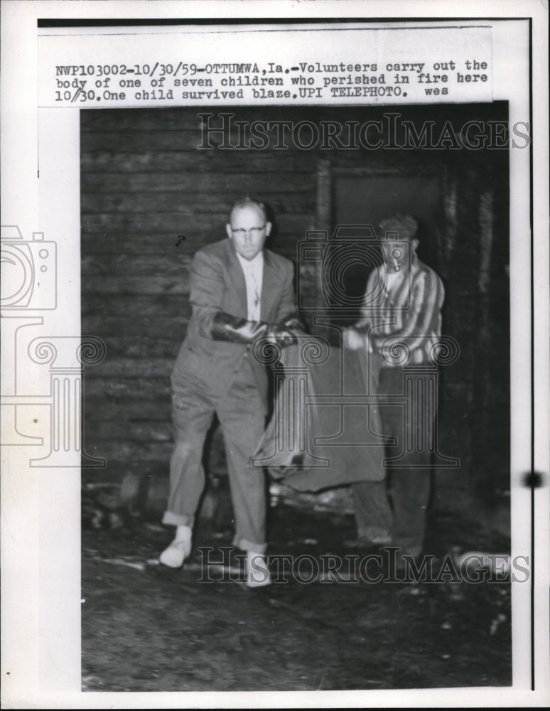 1959 Press Photo Volunteers carry one of the seven dead children of fire - Historic Images