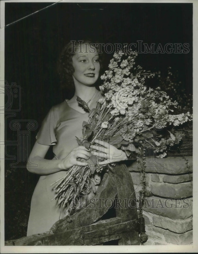 1932 Press Photo Betty Hearn of Cleveland looking at a bouquet of flowers - Historic Images