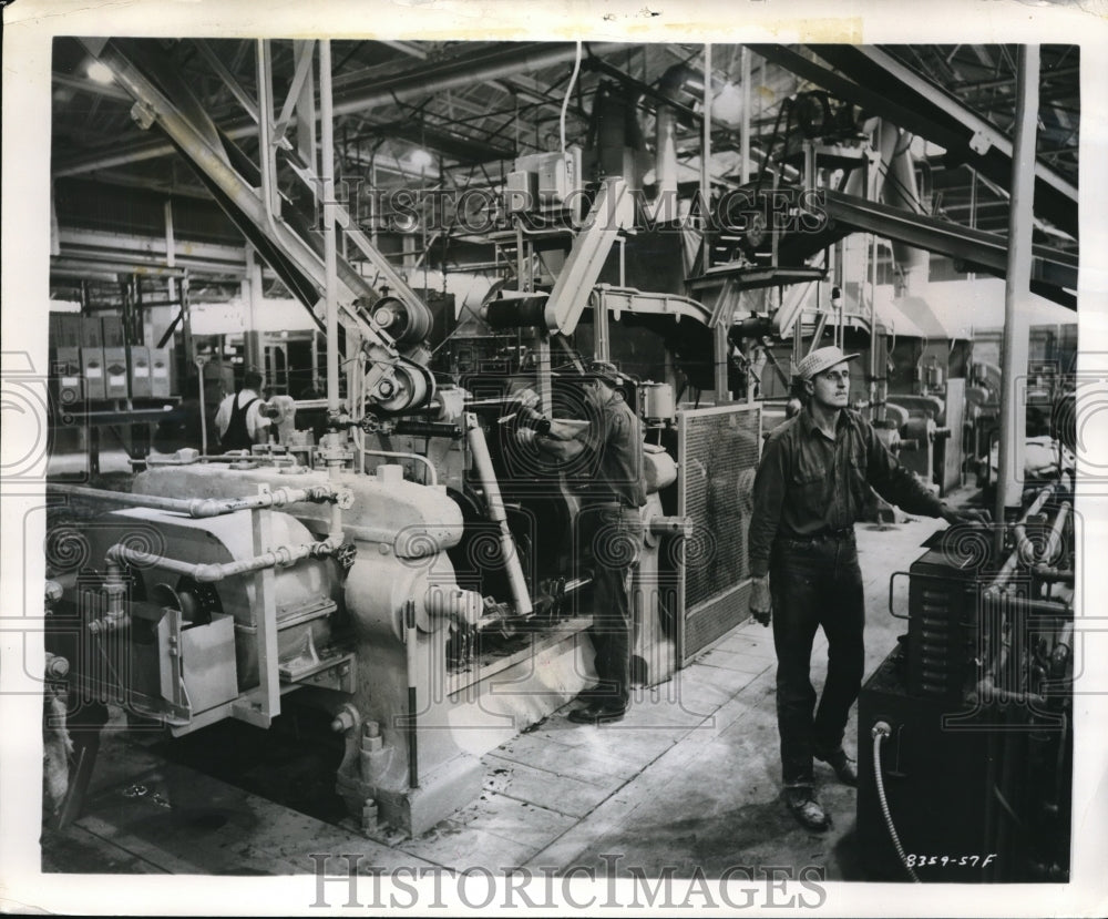 1957 Press Photo Goodyear Tire &amp;Rubber Company. Richard Maj. adjusting feed mill- Historic Images