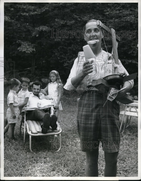 Steven Hill settls down to the children while his wife carrying the apparatus - Historic Images