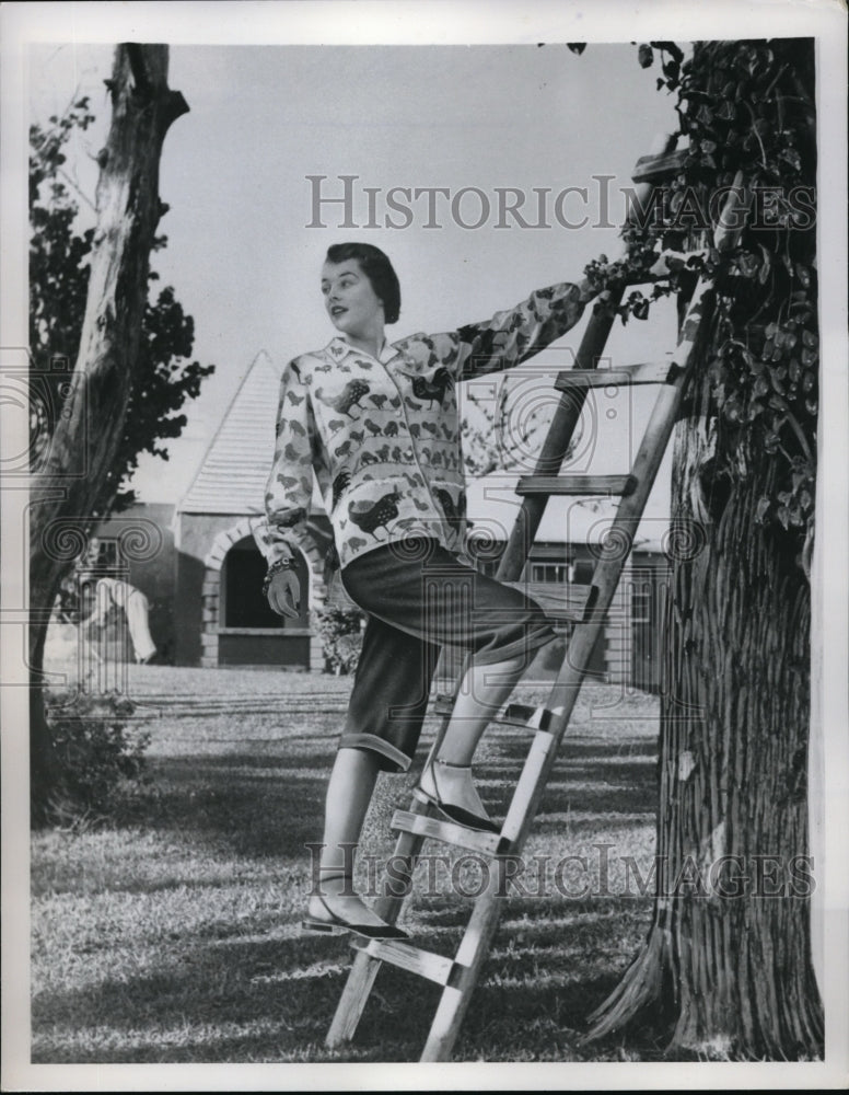 1949 Press Photo Woman Climbs Up Ladder To Hang Flowers - Historic Images