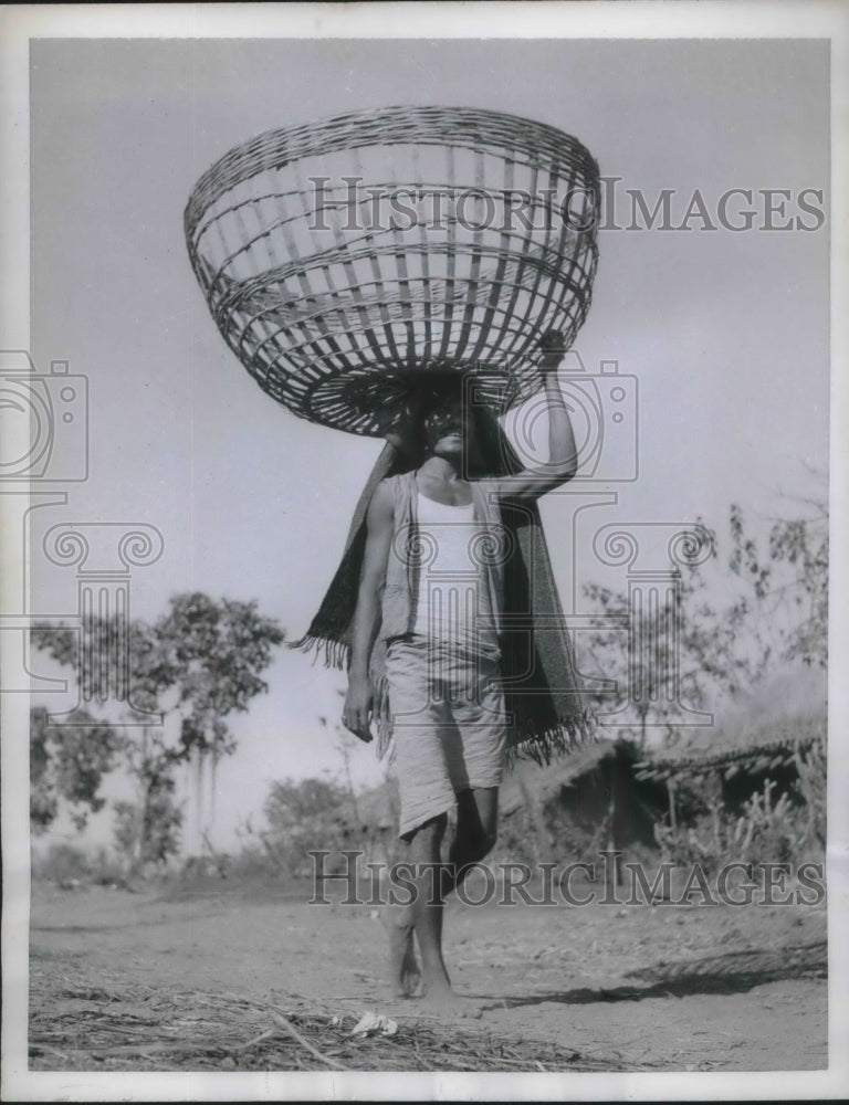 1959 Press Photo India, farmer balancing basket on head in remote village - Historic Images